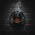 A steaming cup of British tea centered on a dark moody background